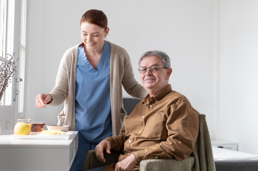 A caregiver and an older adult smiling together