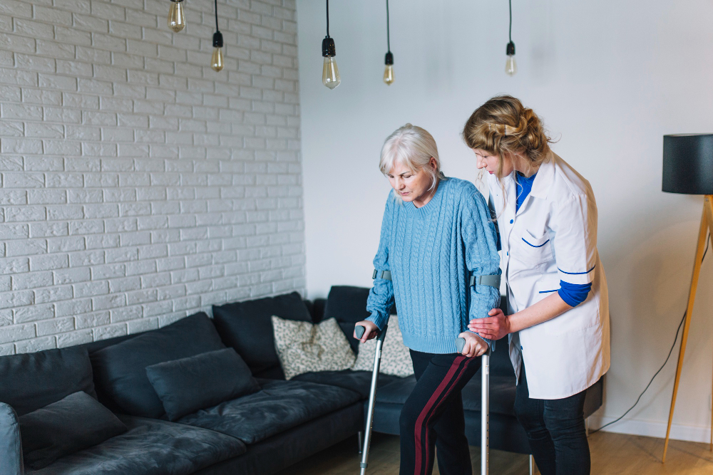 A Care Partner supporting an older woman as she walks at home