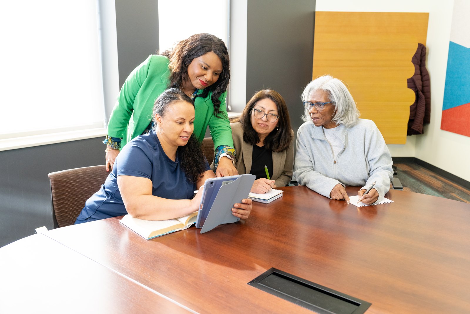 The IHCI team gathered around a table reviewing a care plan with a client