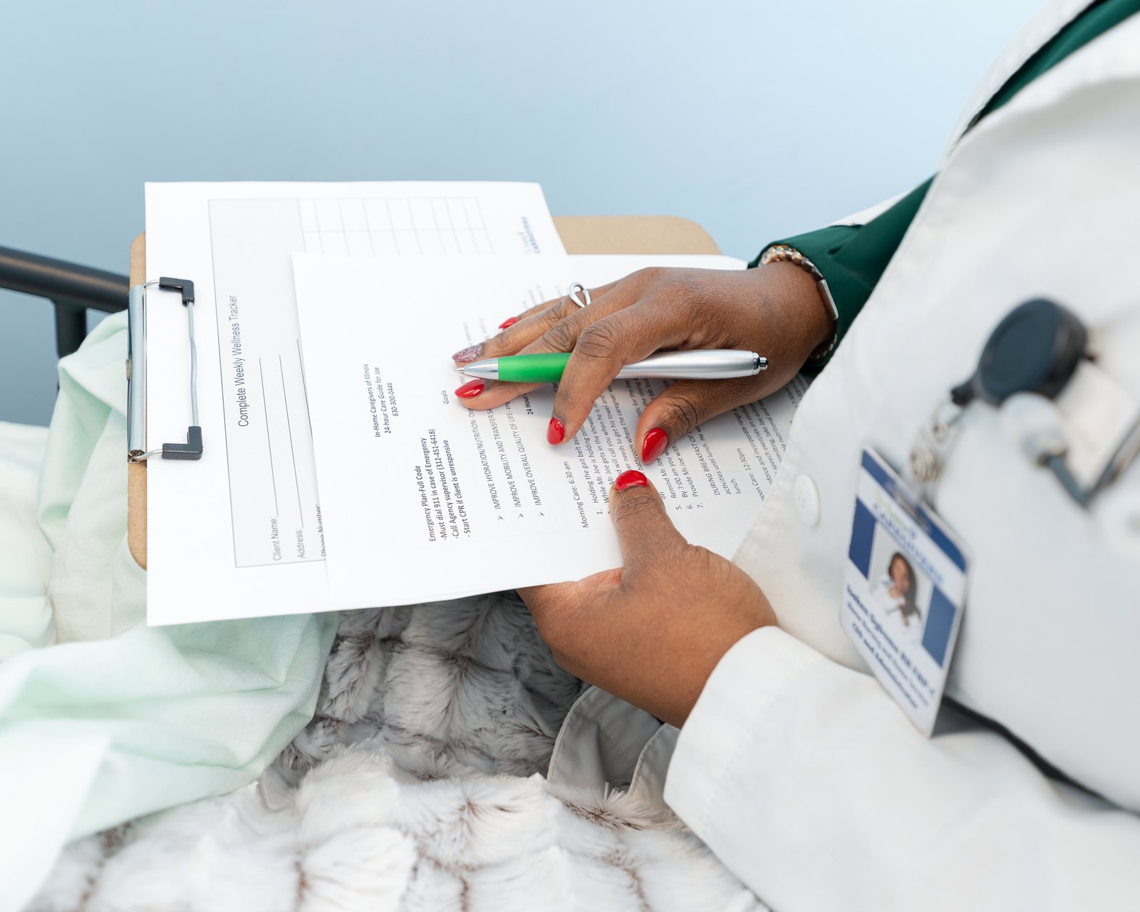 A clinician reviewing notes on a clipboard during a home visit
