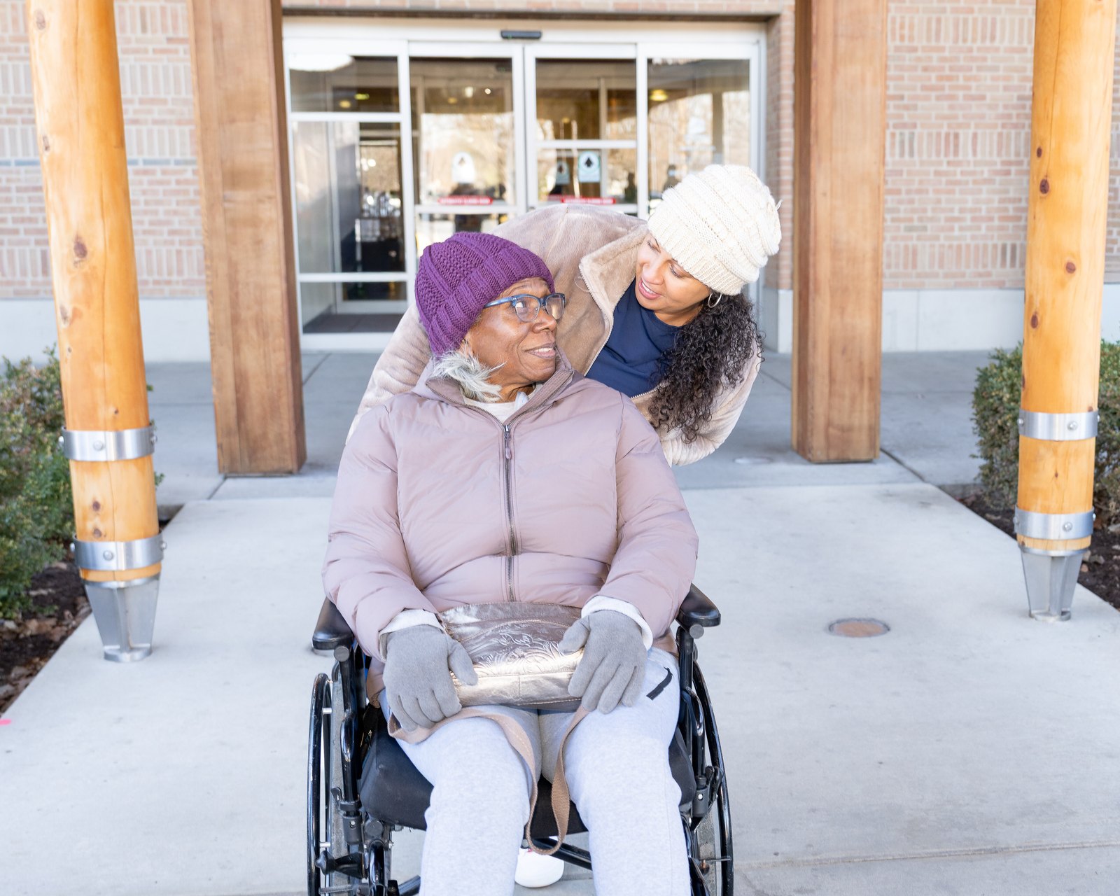 A Care Partner walking outdoors with a client in a wheelchair