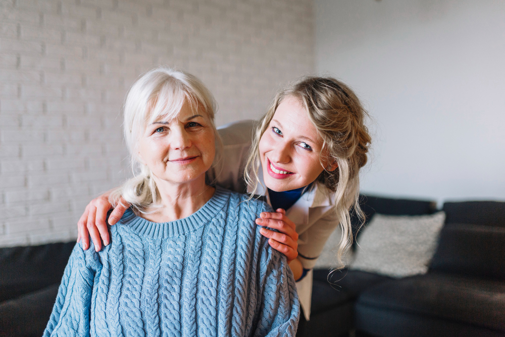 A Care Partner standing beside an older woman in her living room