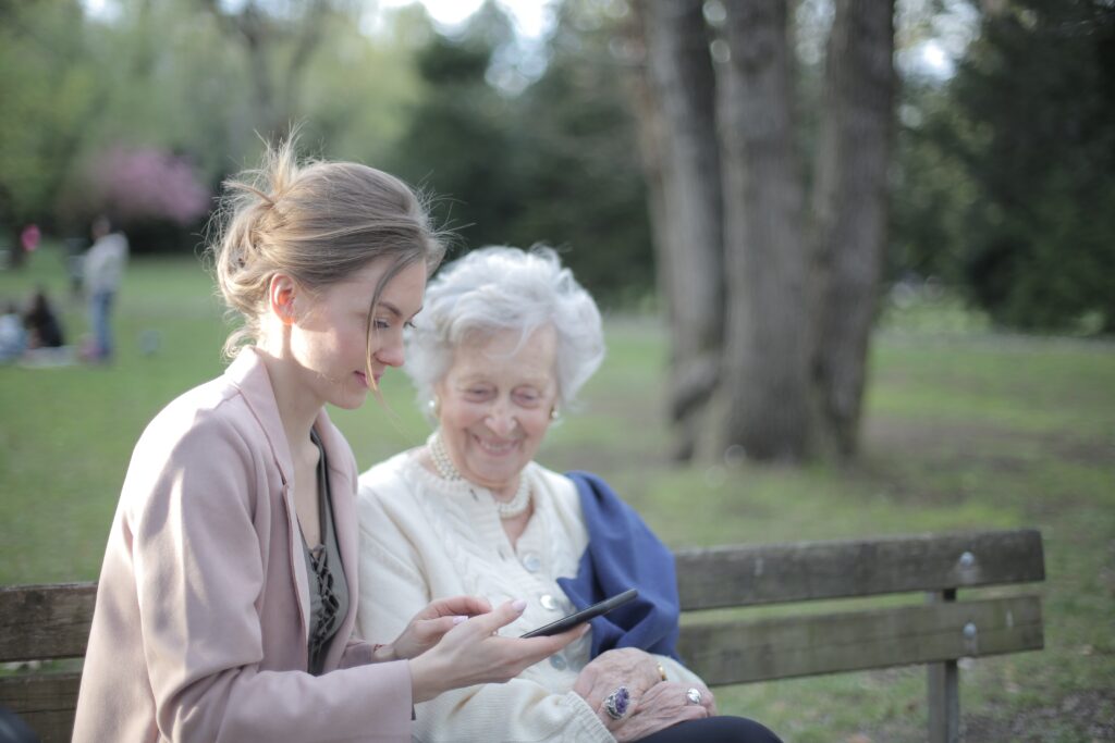 A companion sitting outdoors with an older woman