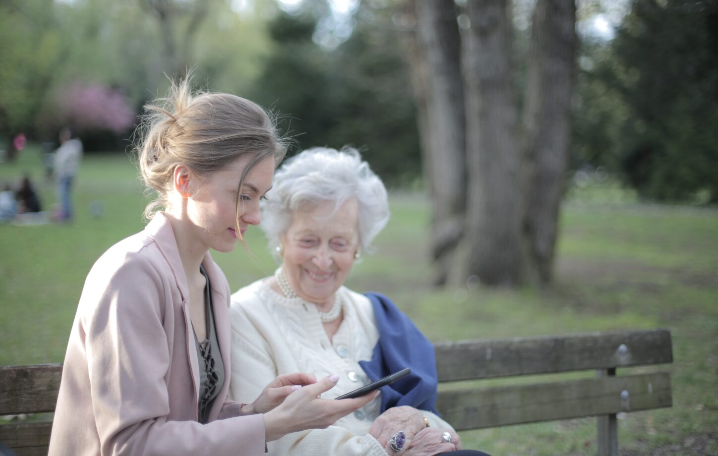 A companion sitting outdoors with an older woman