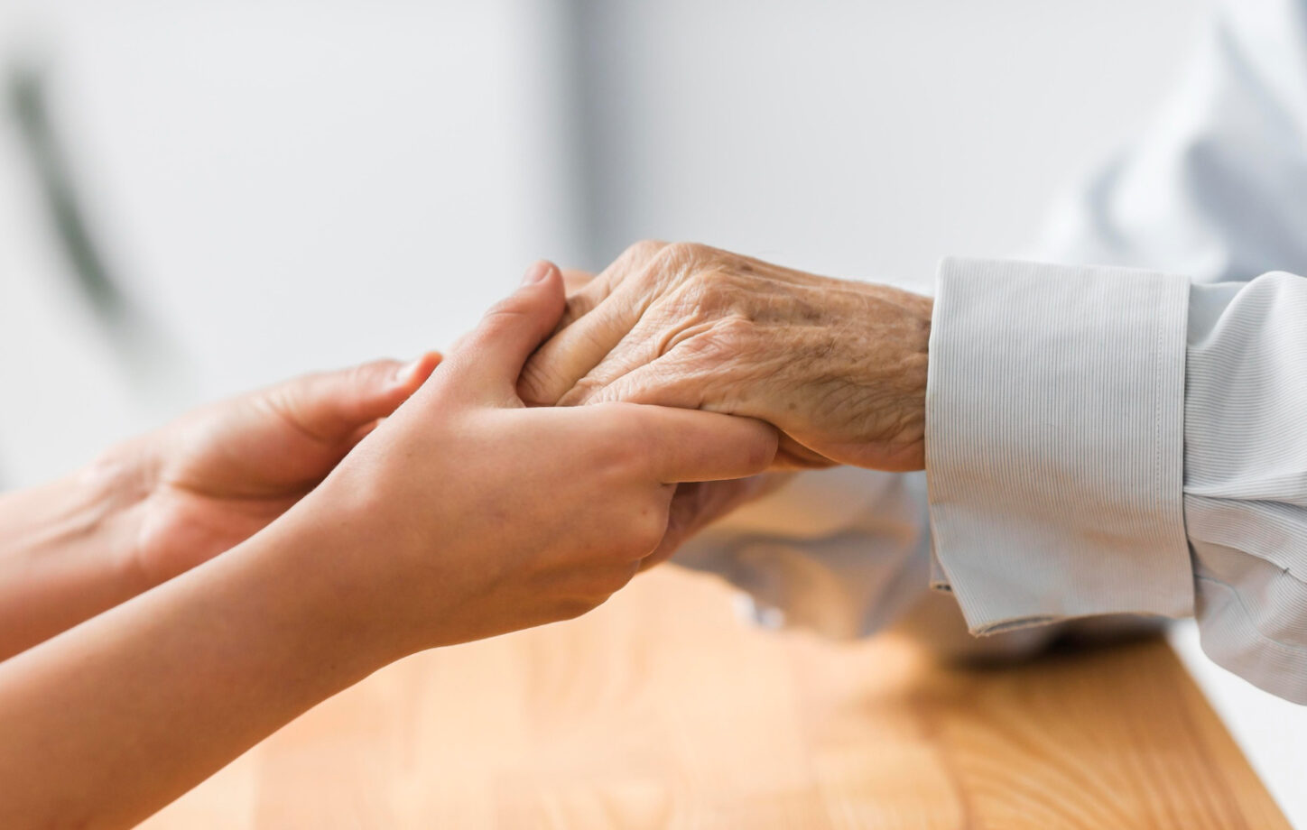 A Care Partner holding an older adult’s hand