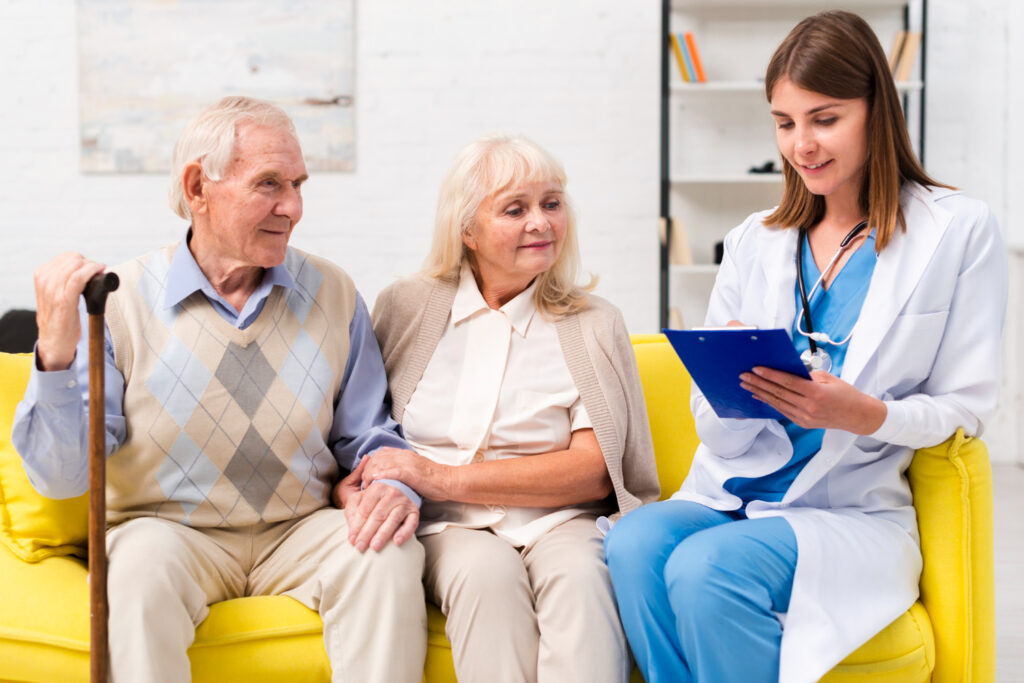 A nurse reviewing a care plan with an older couple at home