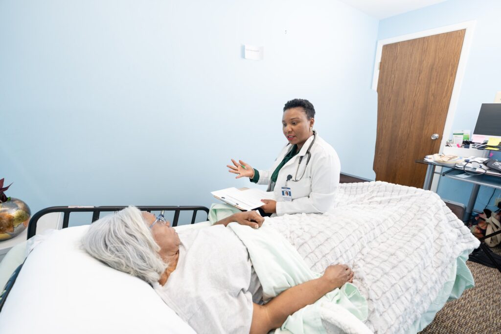 A nurse talking with a client at the bedside about support at home