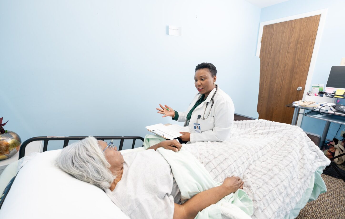 A nurse talking with a client at the bedside about support at home